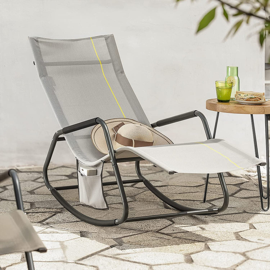 Grå solseng med gyngende stel på dansk terrasse med sidebord, hat og drinks i sommerlys