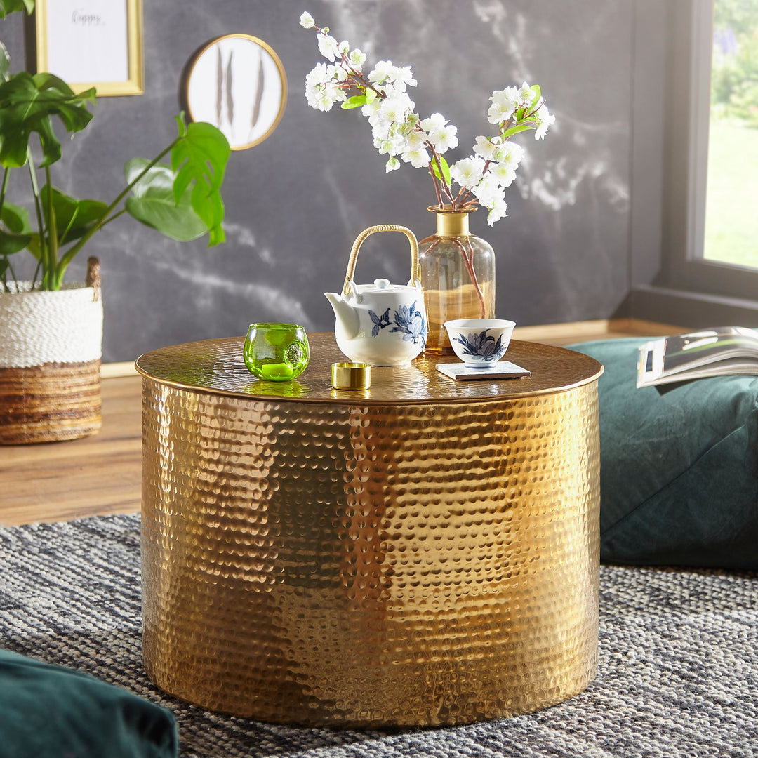 Rundt sidebord i hamret aluminium med bronze finish til altan, vase med kirsebærblomster, tekop og indendørs lifestyle setup