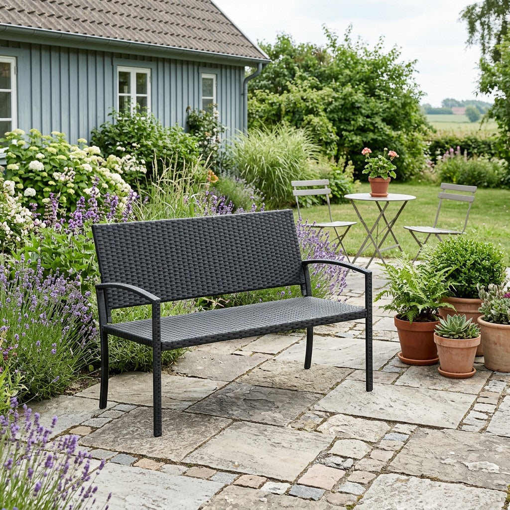 Sort havebænk på fliseterrasse hvor benene står plant og underlaget giver en rolig siddeplads