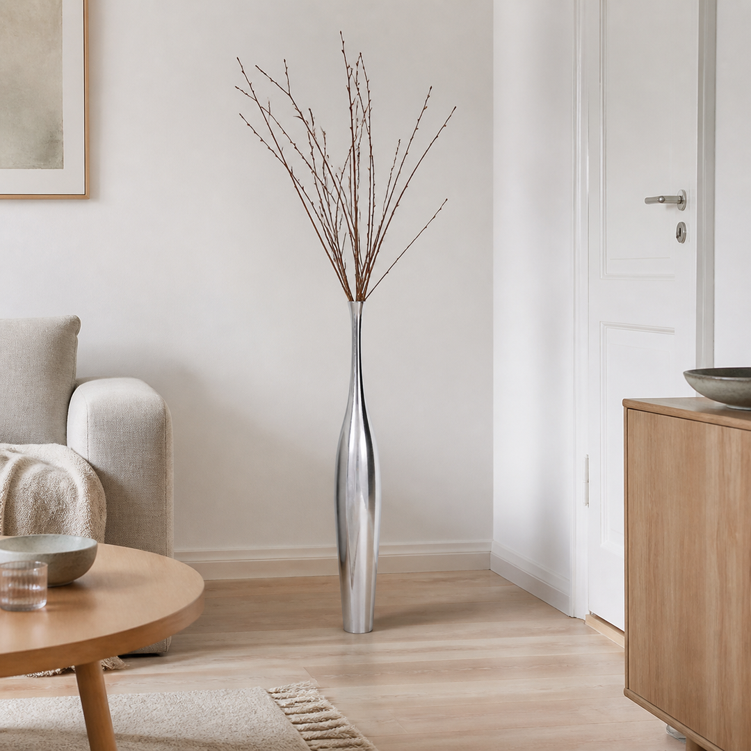 Vasen der giver høje grene ro vist med Blomstervase i aluminium, sølvfarvet i et realistisk, beboet dansk hjem