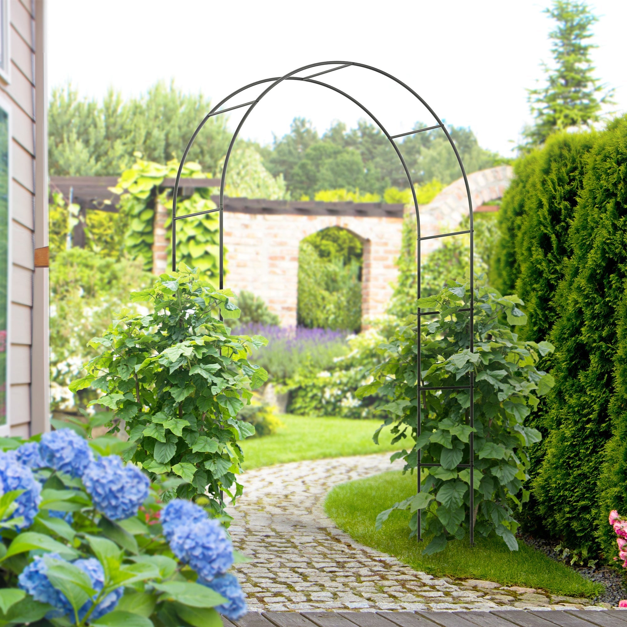 Sort metal havebue espalier 1,40 m bred opstillet i klassisk romantisk have med klatreplanter og hortensiaer