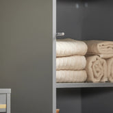 Elegant grå højskab med masser af plads: Perfekt til opbevaring af håndklæder, toiletpapir og rengøringsmidler