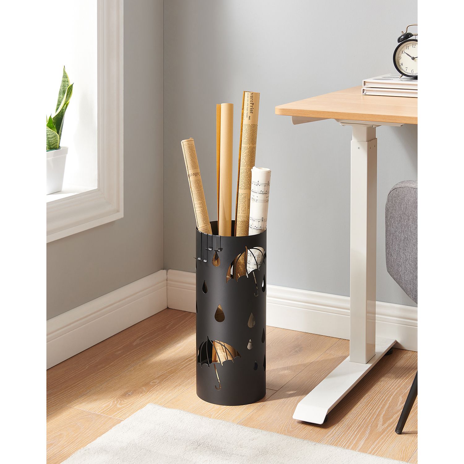 Rund sort metalparaplyholderen med aftagelig vandbakke og fire kroge til paraplyer