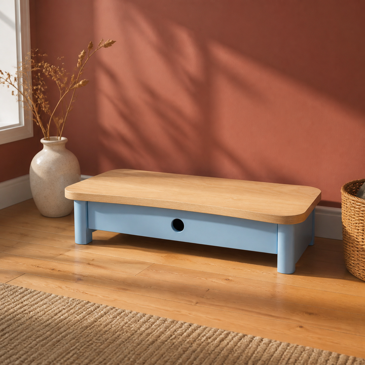 Monitorskærmstativ i askefinér og Gentle Blue mod dyb featurevæg i dagslys