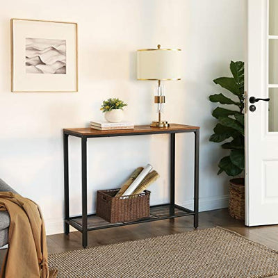 Konsolbord med trådhylde i industrielt look med lampeskærm, bøger og en lille plante placeret i stuen, hovedsageligt ved indgangsdøren