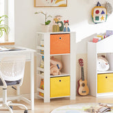 Hyldehylde med sidehylder og 2 stofskuffer placeret på kontoret i soveværelset ved siden af kontorbordet og -stolen fyldt med legetøj og bøger