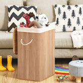  Fyldt med mange legetøj indeni, Vasketøjskurv med låg og aftagelig bomuldspose placeret ved siden af sofaen i et stue miljø