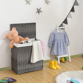 Grå polyrattan håndvævet vasketøjskurv fyldt med bamser og tøj i et soveværelsesmiljø