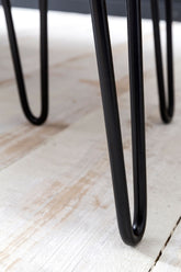 Nærbillede af sofabordets sorte metalben, som er buede.